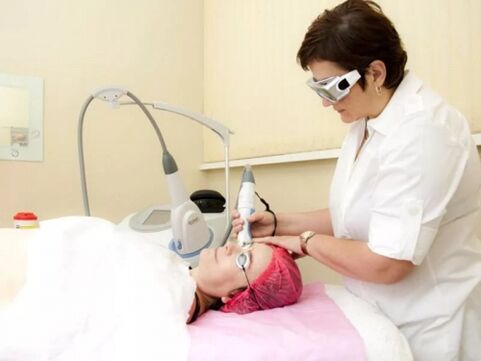 The cosmetologist performs the laser rejuvenation procedure